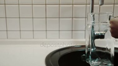 Adam mutfak Daire temiz su sürahi doldurur.