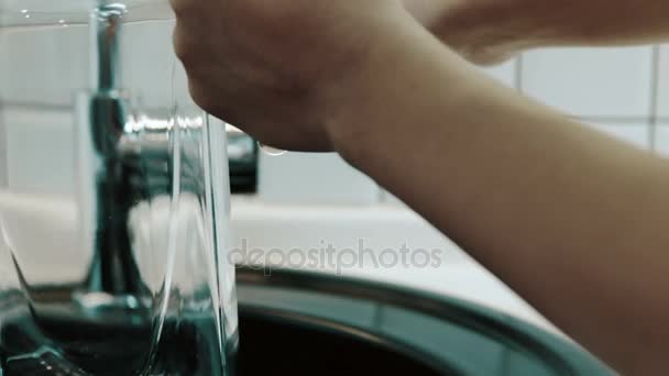 Mann füllt Glaskaraffe mit sauberem Leitungswasser, in dem sich Blasen befinden. — Stockvideo