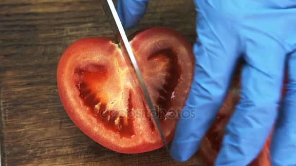 Koch in Handschuhen schneidet halbe Tomate in Küche eines Restaurants. — Stockvideo