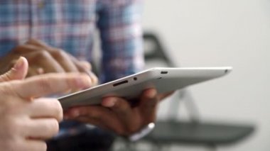 Afroamerican adam bilgi için onun tablet üzerinde görünüyor ve kadın arkadaşı ona yardımcı olur.