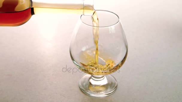 O vidro limpo está sendo preenchido com conhaque de ouro de alta qualidade no restaurante . — Vídeo de Stock