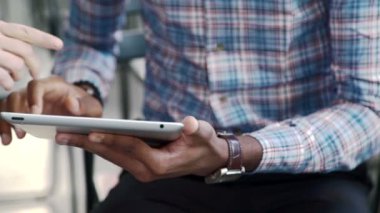 İki kişi hafif ofiste otururken tablet kullanarak iletişim.