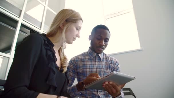 Woman and man talking, using tablet in modern office. — Stock Video