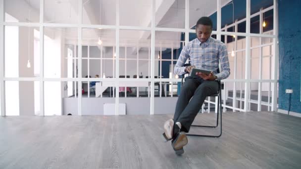 Jeune homme d'affaires utilise tablette tout en étant assis dans la société leader . — Video