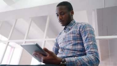 Başarılı bir iş adamı tablet, önde gelen şirketi ayakta kullanır.