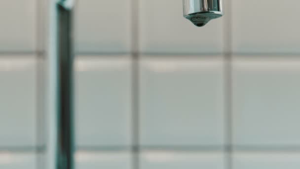 Gros plan d'un robinet en métal dans la salle de bain goutte à goutte .