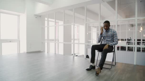 현대 사무실에 앉아있는 동안 전화 통화 하는 젊은 사업가. — 비디오