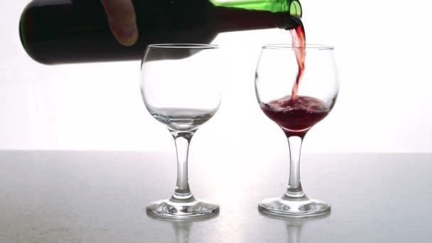 The two cristall glasses is being fulfilled with the red dry wine with rich bouquette in the restaurant bar. — Stock Video