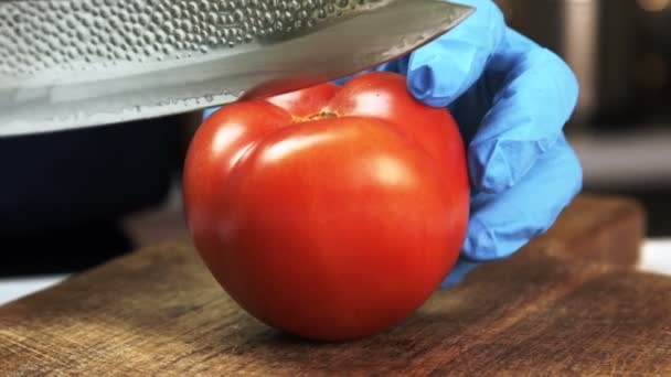 Lâmina afiada cortada em meio tomate vermelho maduro na placa de madeira . — Vídeo de Stock