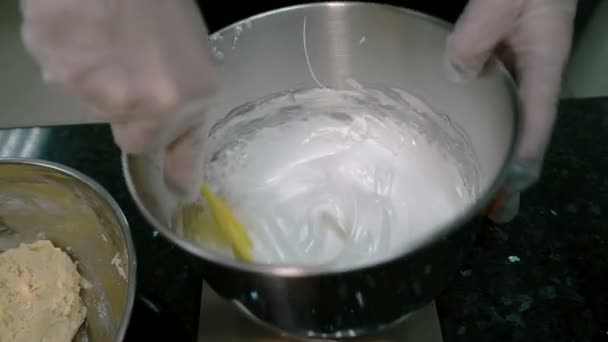 Chef com uma pá mistura a mistura de proteína com a massa em uma tigela . — Vídeo de Stock