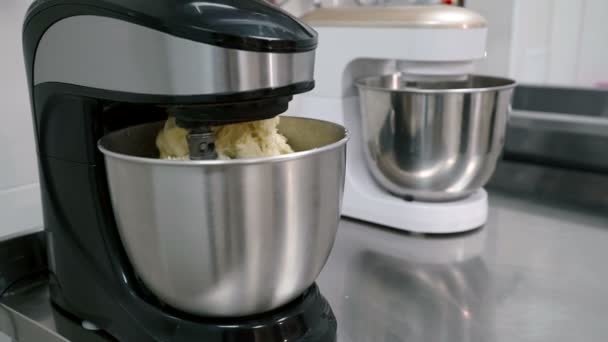 Los batidores eléctricos en blanco y negro están mezclando la masa en ollas de acero en la cocina del restaurante . — Vídeos de Stock