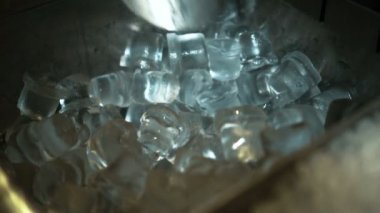 Bir kürek ile bir adam Close-Up buz dilimleri bir kokteyl için alır.