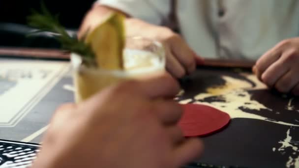 Barmen está dando um delicioso coquetel amarelo para o cliente masculino em bar elegante, de perto . — Vídeo de Stock
