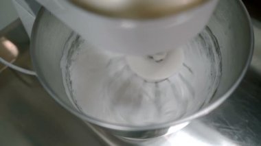 Karıştırıcı kalın bir kitle dövülmüş yumurta akı.