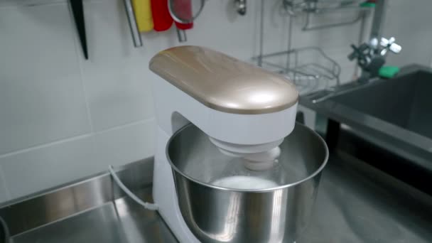 Mélangeur crème blanche fouettée sur la table dans la cuisine de la maison à l'intérieur . — Video