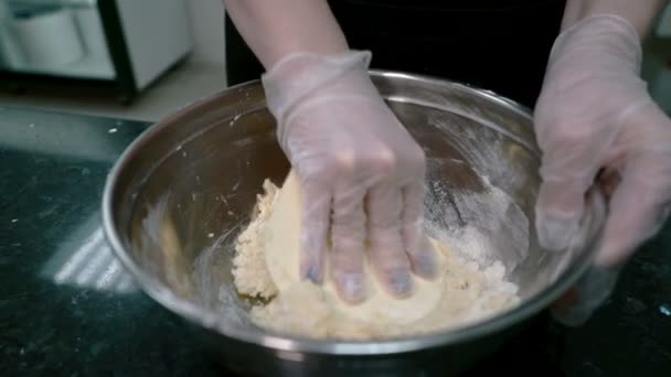 Руки женской кондитерской смешивают тесто в металлическую миску, закрывают . — стоковое видео