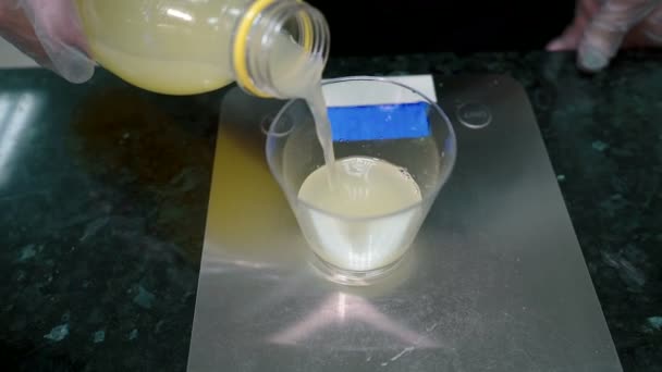 Cuire à l'échelle mesure la portion de liquide jaune et l'ajoute à la pâte de farine . — Video