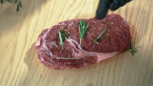 Jonge chef-kok hagelslag biefstuk met rozemarijn in de keuken van restaurant. — Stockvideo