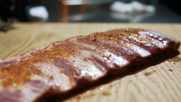 Las arrugas profesionales el condimento a los pedazos de la carne a la mesa en la cocina . — Vídeos de Stock
