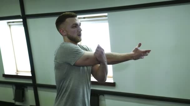 Portrait de jeune sportif, qui fait des exercices d'échauffement dans la salle de gym moderne, au ralenti . — Video