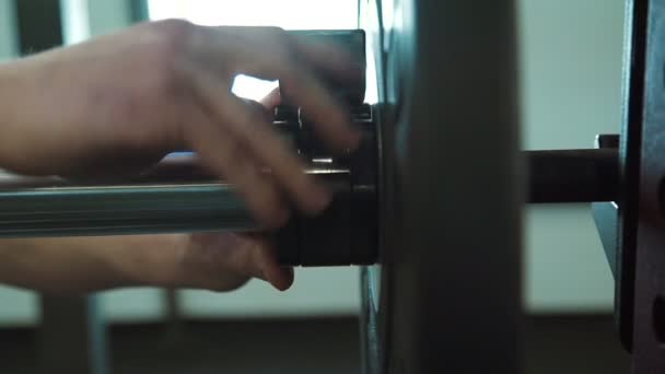 Close-up van de hand bevestigt voor disc lock op barbell voor powerlifting. — Stockvideo