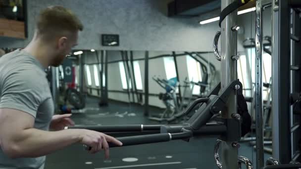 Portret młodzieńca, który robi klatki piersiowej wersja ćwiczenia spadki w nowoczesnej siłowni. — Wideo stockowe