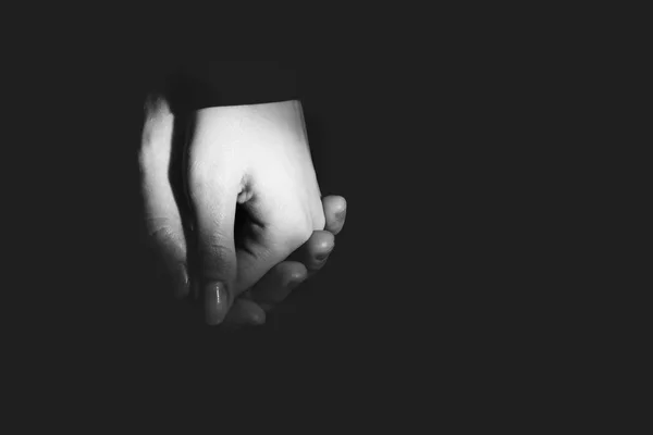 male and female hands in a gentle touch on a black background. Black and white photo