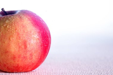 hafif arkaplanda su damlalarında sulu kırmızı elma