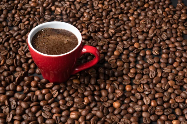 coffee in a red cup on a background of coffee beans