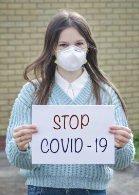 Koruyucu tıbbi maskeli bir kız virüslere karşıdır.