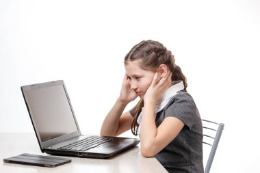 Beyaz arka planda dizüstü bilgisayarın başında oturan tatlı bir kız öğrenci.