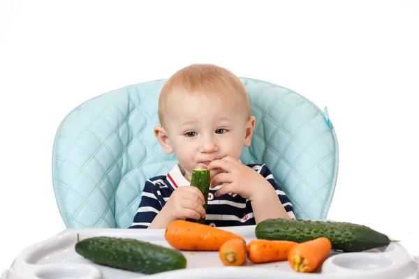 Bambino Allegro Seduto Seggiolino Bambini Mangiare Cetriolo Verde Uno Sfondo — Foto Stock