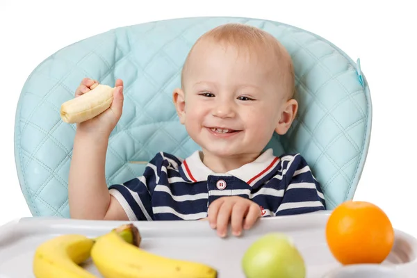 Веселый Мальчик Сидит Детском Кресле Ест Свежие Бананы Белом Фоне — стоковое фото