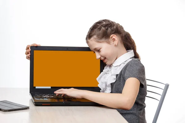 Studentessa carina seduta a un computer portatile su uno sfondo bianco — Foto Stock