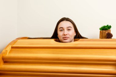 Güzel kız spa odasında aroma saunasında oturur ve eğlenir.