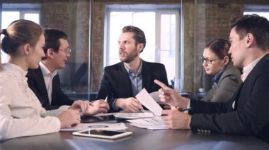 İş ortakları toplantıda belge ve fikirleri tartışıyor