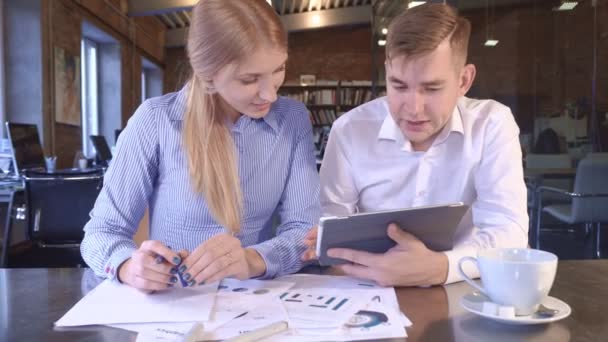 Miembros del equipo Mujer y hombre miran una tableta juntos — Vídeos de Stock