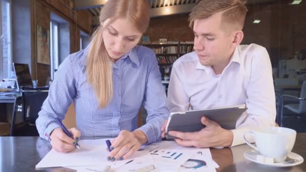 Miembros del equipo Mujer y hombre miran una tableta juntos — Vídeos de Stock