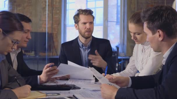 Geschäftspartner diskutieren bei Treffen über Dokumente und Ideen — Stockvideo