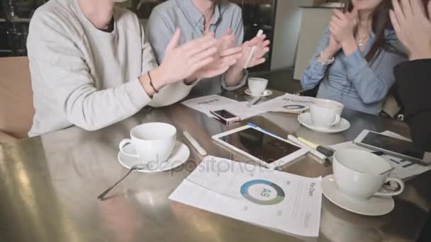 Feliz equipo de negocios joven con la tableta, documentos y café aplaudiendo mano — Vídeos de Stock