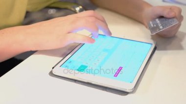Genç bir kadın onun tablet bilgisayar ve kredi kartı kullanarak internette alışveriş