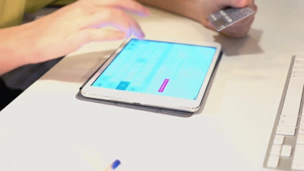 Genç bir kadın onun tablet bilgisayar ve kredi kartı kullanarak internette alışveriş — Stok video