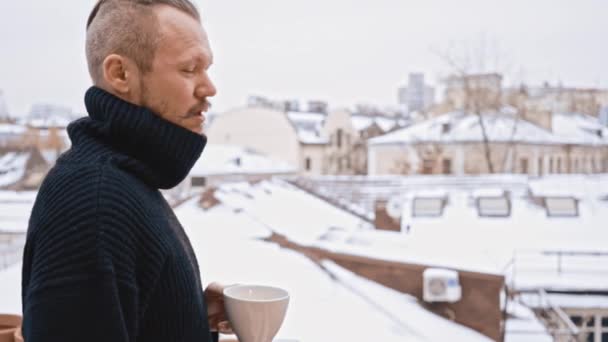 Junger Mann mit Schnauzbart und Kaffeetrinker auf dem Dach. Winter — Stockvideo