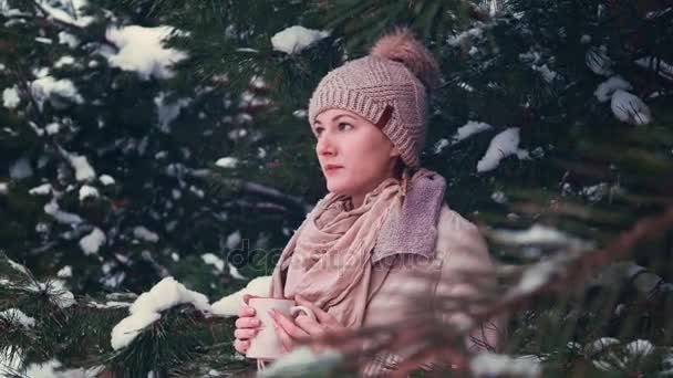 Woman Drinks Hot Tea or Coffee From a Cup on Snowy Winter Morning Outdoors. — Stock Video