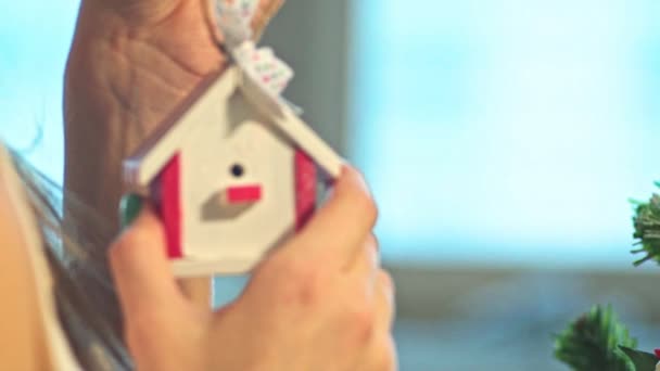 Nya huset på granen. Inteckning. Ung kvinna sätter leksaker på en julgran. Slow Motion — Stockvideo