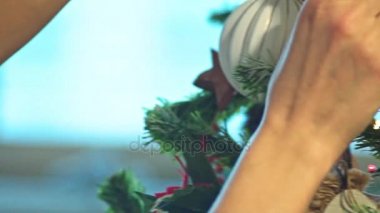 Yeni ev Noel ağacı. İpotek. Genç kadın oyuncak bir Noel ağacına koyuyor. Ağır çekim