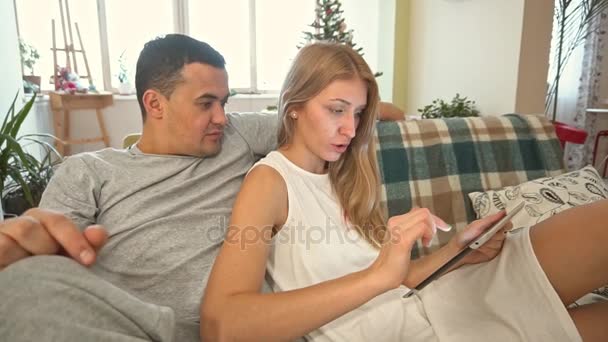 Pareja joven usando tableta PC en casa. En Navidad. Moción lenta — Vídeos de Stock