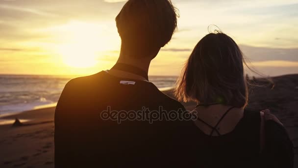 Pareja en la orilla del mar, pareja romántica al atardecer. Dos personas enamoradas al atardecer. Hombre y mujer en la playa — Vídeo de stock