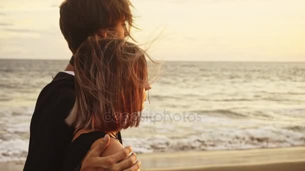 Pár romantikus pár napnyugtakor a tenger partján. Két ember szerelmes a naplemente. Férfi és nő a tengerparton — Stock videók