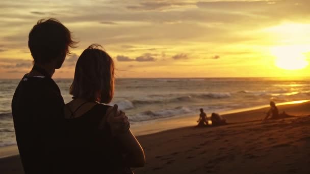 Een man hugs een vrouw, romantisch paar bij zonsondergang. Twee mensen in liefde bij zonsondergang. — Stockvideo